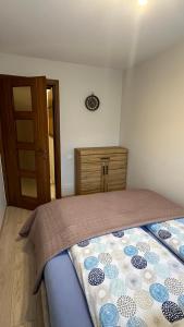ein Schlafzimmer mit einem Bett und einer Holzkommode in der Unterkunft Central Boulevard Apartment 2 in Šiauliai