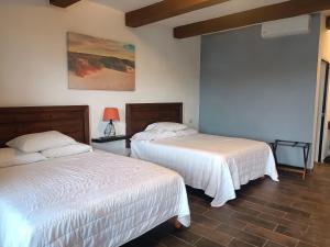 2 camas en una habitación con sábanas blancas en Hacienda Viga 2020 Hotel, en Cuatrociénegas de Carranza