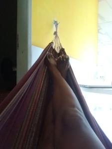 a person laying in a hammock with their feet up at Beach House in Salinas da Margarida