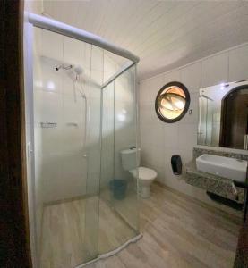 a bathroom with a glass shower and a toilet at Pousada Estrela Dalva in Penha