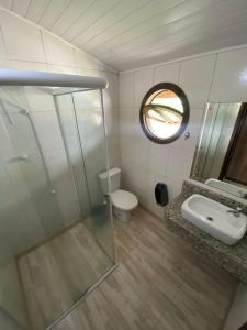 a bathroom with a toilet and a sink and a mirror at Pousada Estrela Dalva in Penha