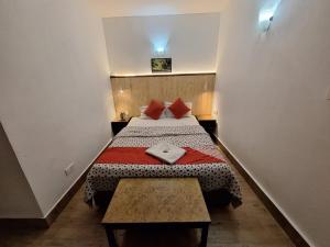 um pequeno quarto com uma cama e uma mesa em Pemathang Hotel em Gangtok