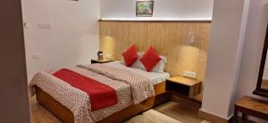 um quarto com uma cama com almofadas vermelhas em Pemathang Hotel em Gangtok