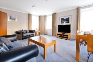 a living room with a couch and a tv at New Lanark Self Catering Waterhouses in Lanark