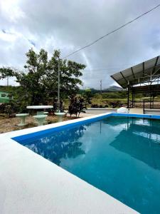 a large blue swimming pool with a picnic table at Miravalles Volcano House in Guayabal