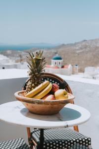 uma taça de fruta numa mesa com ananás em SELANA Suites Chora em Serifos Chora