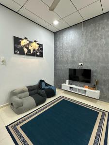 a living room with a couch and a tv at HOMESTAY IZHAN BANDAR KUALA TERENGGANU in Kuala Terengganu