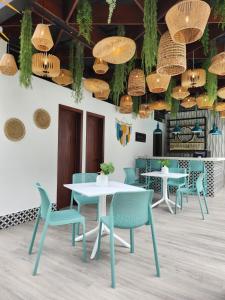 une salle à manger avec des tables, des chaises et des lustres dans l'établissement Hotel Tepeu, à Santa Elena