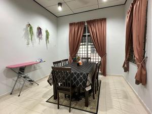 a dining room with a table with chairs and a window at HOMESTAY IZHAN BANDAR KUALA TERENGGANU in Kuala Terengganu