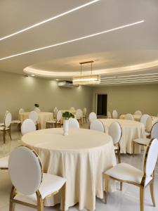 una sala de conferencias con mesas y sillas blancas en Hotel Tepeu, en Santa Elena