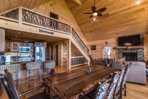 a dining room and living room with a large wooden table at Majestic mountaintop cabin, hot tub, fireplaces in Craytonia