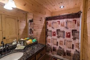 a bathroom with a sink and a shower curtain at Majestic mountaintop cabin, hot tub, fireplaces in Craytonia +43 photos