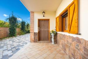 a house with a wooden door and a stone wall at Villa Rosy Casa Vacanze in Campomarino