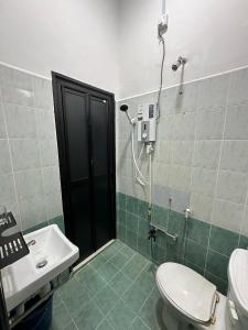 a bathroom with a shower and a toilet and a sink at HOMESTAY IZHAN BANDAR KUALA TERENGGANU in Kuala Terengganu +11 photos
