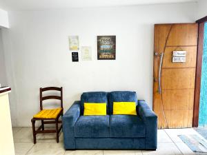 a blue couch with yellow pillows in a living room at Hostel Welcome SP - Congonhas in Sao Paulo
