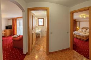 een kamer met een slaapkamer met een bed en een badkamer bij Hotel Rosslaufhof in Castelrotto