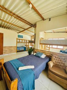 een slaapkamer met een groot bed en een bank bij Capitan Brau's in Los Órganos
