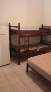 Pokój z 2 łóżkami piętrowymi i lodówką w obiekcie Suítes Vila do Surf , a original , desde 2010 w mieście Ubatuba