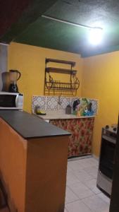 a kitchen with a counter top in a room at Suítes Vila do Surf , a original , desde 2010 in Ubatuba