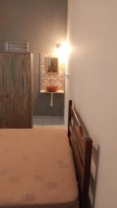 sypialnia z łóżkiem oraz łazienka z umywalką w obiekcie Suítes Vila do Surf , a original , desde 2010 w mieście Ubatuba