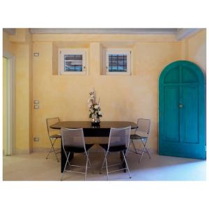 ein Esszimmer mit einem Tisch, Stühlen und einer blauen Tür in der Unterkunft Appartamento Virginia in Monti di Licciana Nardi