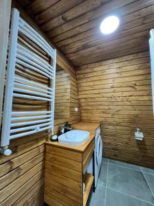 a wooden bathroom with a sink and a toilet at Gudauri Sikhaura in Kʼumlistsʼikhe