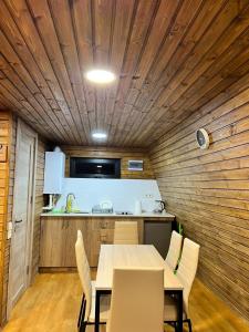 a dining room with a table and a kitchen at Gudauri Sikhaura in Kʼumlistsʼikhe +6 photos
