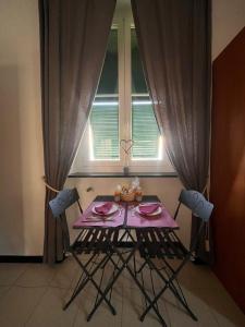 einen lila Tisch mit Stühlen in einem Zimmer mit Fenster in der Unterkunft Porta del Parco in Camogli