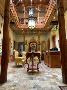 un gran vestíbulo con una mesa y una escalera en Magdalena Hotel & Suites en Cuenca