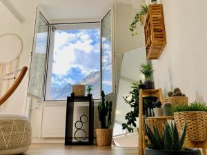 ein Zimmer mit Pflanzen und einem großen Fenster in der Unterkunft EVA o Wellnessoasis o Montainview o Pizzaoven o in Ingenbohl