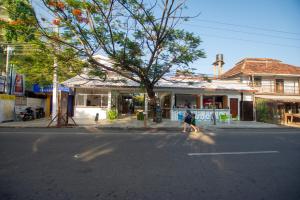 a person crossing a street in front of a store at Arugambay Surf Resort in Arugam Bay