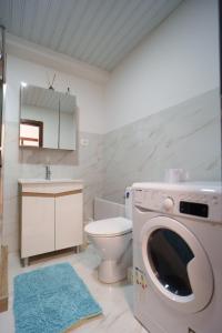 a bathroom with a washing machine and a toilet at Apido apartment in Kavadarci