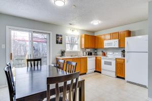 a kitchen with a table and a white refrigerator at Indy Delight Charming House about 10 Mi to Downtown! in Indianapolis