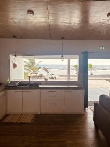 une cuisine avec un évier et une vue sur la plage dans l'établissement Pension Irivai appartement "Uparu" 1 chambre bord de mer, à Uturoa