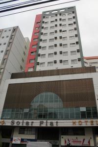 un edificio alto con un cartel en la parte delantera en Solar Flat Hotel, en Juiz de Fora