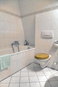 ein Badezimmer mit einem WC, einer Badewanne und einem Waschbecken in der Unterkunft Hotel am Liepnitzsee in Wandlitz