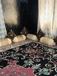 una cama con muchas almohadas y una alfombra en POP Misba Homestay, en Bhadarwāh