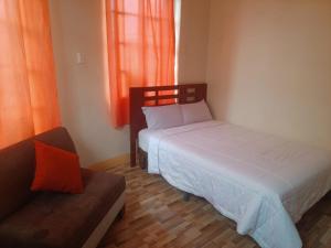 a bedroom with two beds and a couch and a window at Hotel City Central Guayaquil in Guayaquil