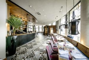 a restaurant with tables and chairs and a bar at Hotel Lilla Roberts in Helsinki