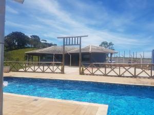 ein Haus mit einem Pavillon neben einem Pool in der Unterkunft Casa Nas Montanhas em Camanducaia Sul de Minas in Camanducaia
