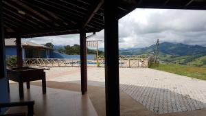 Blick auf ein Haus mit einem Pool und einem Tisch in der Unterkunft Casa Nas Montanhas em Camanducaia Sul de Minas in Camanducaia