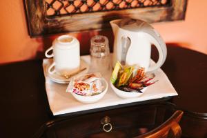 hostel lake plastira في Kalyvia: طاولة عليها غلاية شاي وأكواب