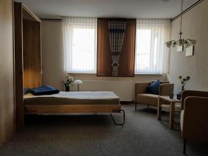 ein Schlafzimmer mit einem Bett, einem Sofa und Fenstern in der Unterkunft Haus Lieberum Apartment Erdgeschoß in Bad Sooden-Allendorf