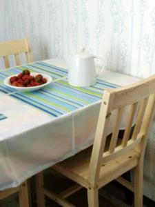stół z miską owoców i talerzem truskawek w obiekcie Apartament w Willi Lemoniada w Ustce