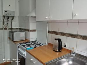 a kitchen with a sink and a stove top oven at Apartament w Willi Lemoniada in Ustka