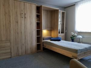 ein Schlafzimmer mit einem Bett und einem großen Holzschrank in der Unterkunft Haus Lieberum Apartment Erdgeschoß in Bad Sooden-Allendorf