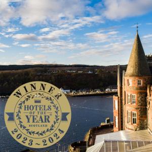 a sign for the hotel of the year with a view of the water at Western Isles Hotel in Tobermory