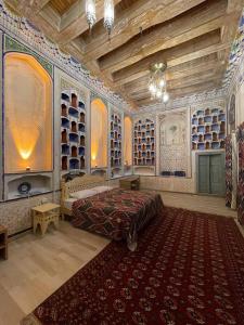 a bedroom with a large bed in a room with shelves at Bibi-Khanym Hotel in Bukhara