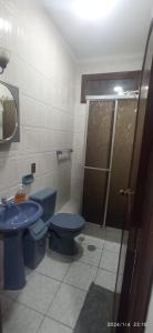 W łazience znajduje się niebieska toaleta i umywalka. w obiekcie Para pareja o familia de 3 integrantes w mieście La Paz