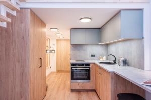 een keuken met houten kasten en een fornuis met oven bij City Sky Loft in Vilnius in Vilnius